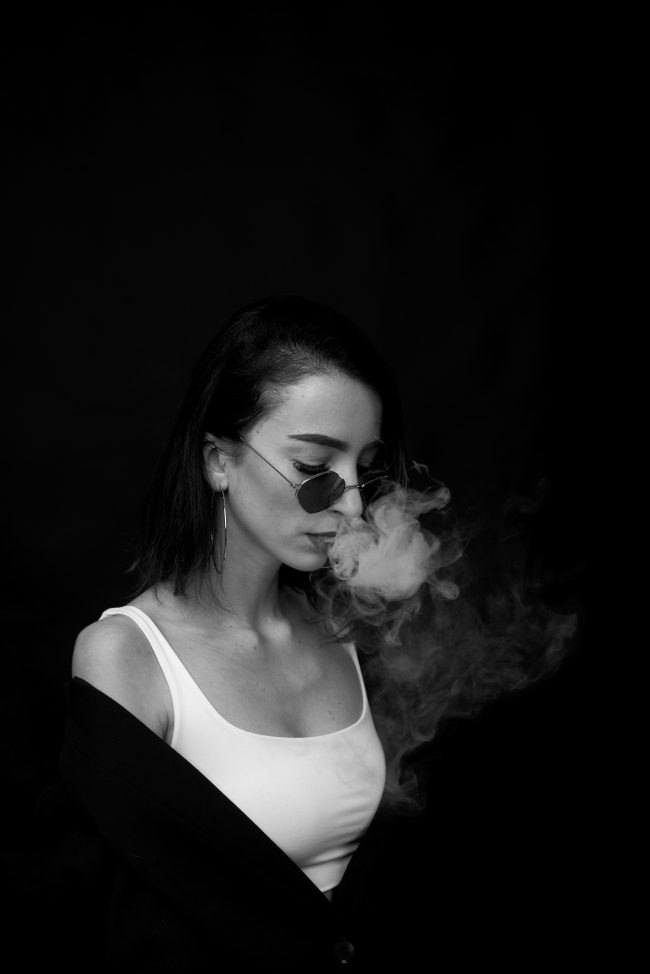 Girl vaping on black background